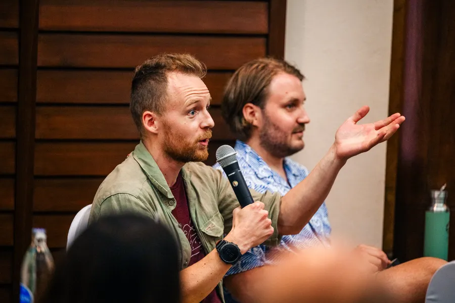 Two workshop participants in discussion, one holding a microphone