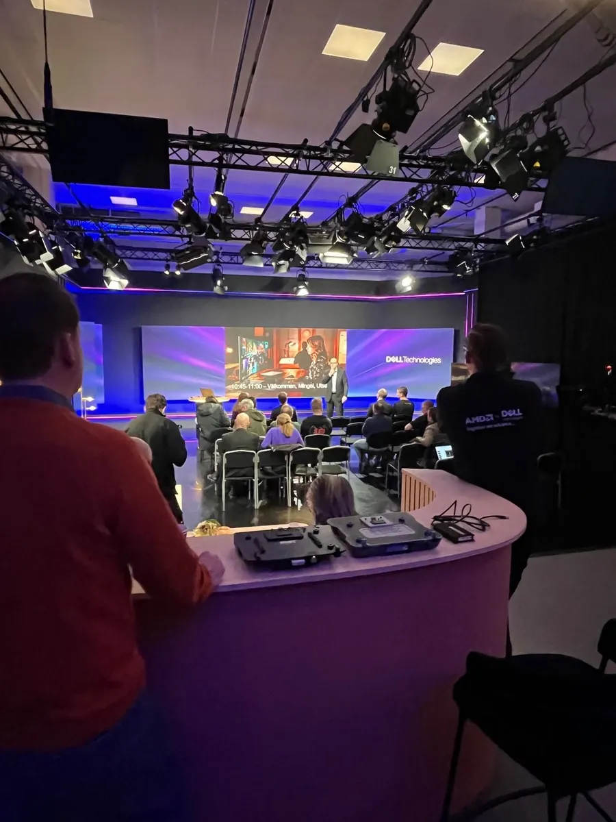 An audience in a studio watching an immersive storytelling presentation on a large screen