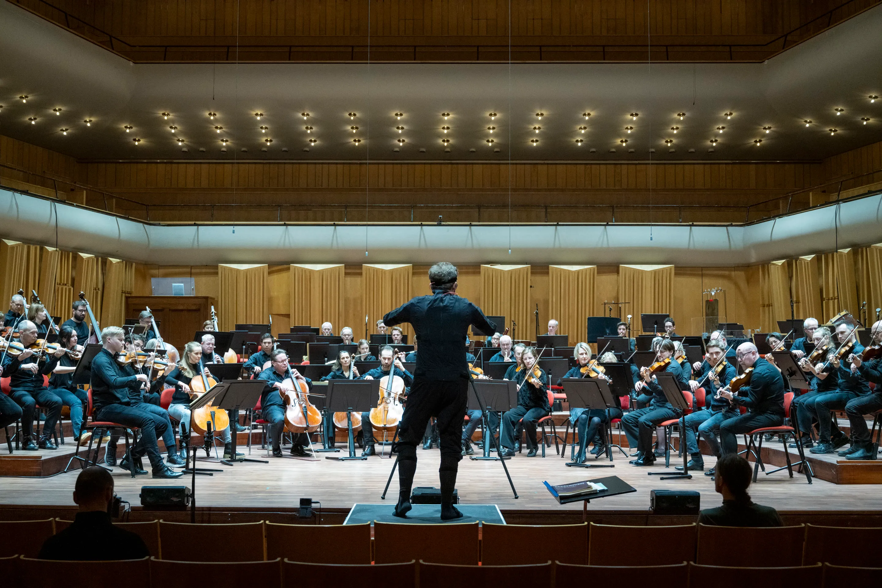 Dirigenten leder hela orkestern i konserthuset under inspelningssessionen