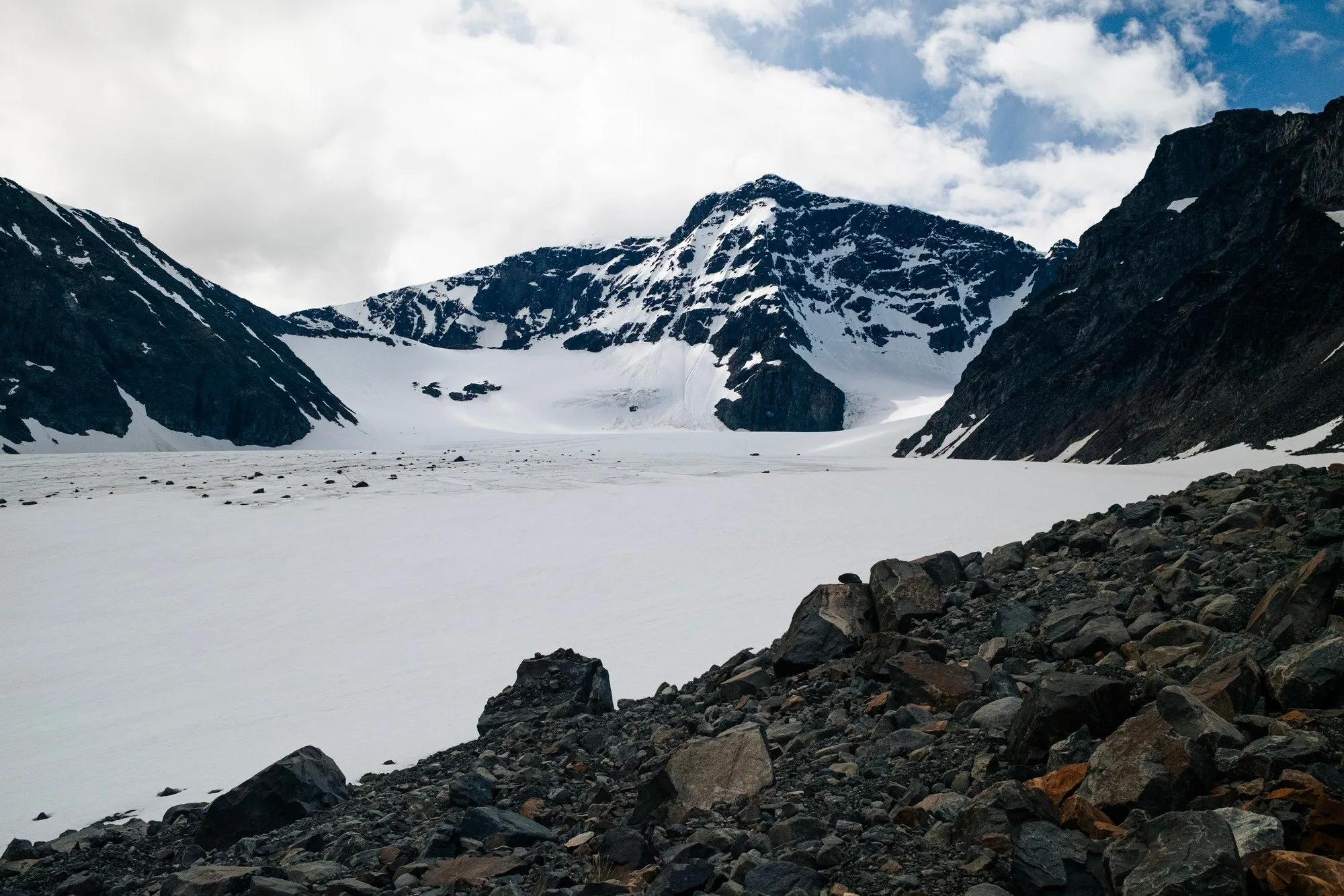 Storglaciären stretching between dark peaks, seen from the rocky moraine