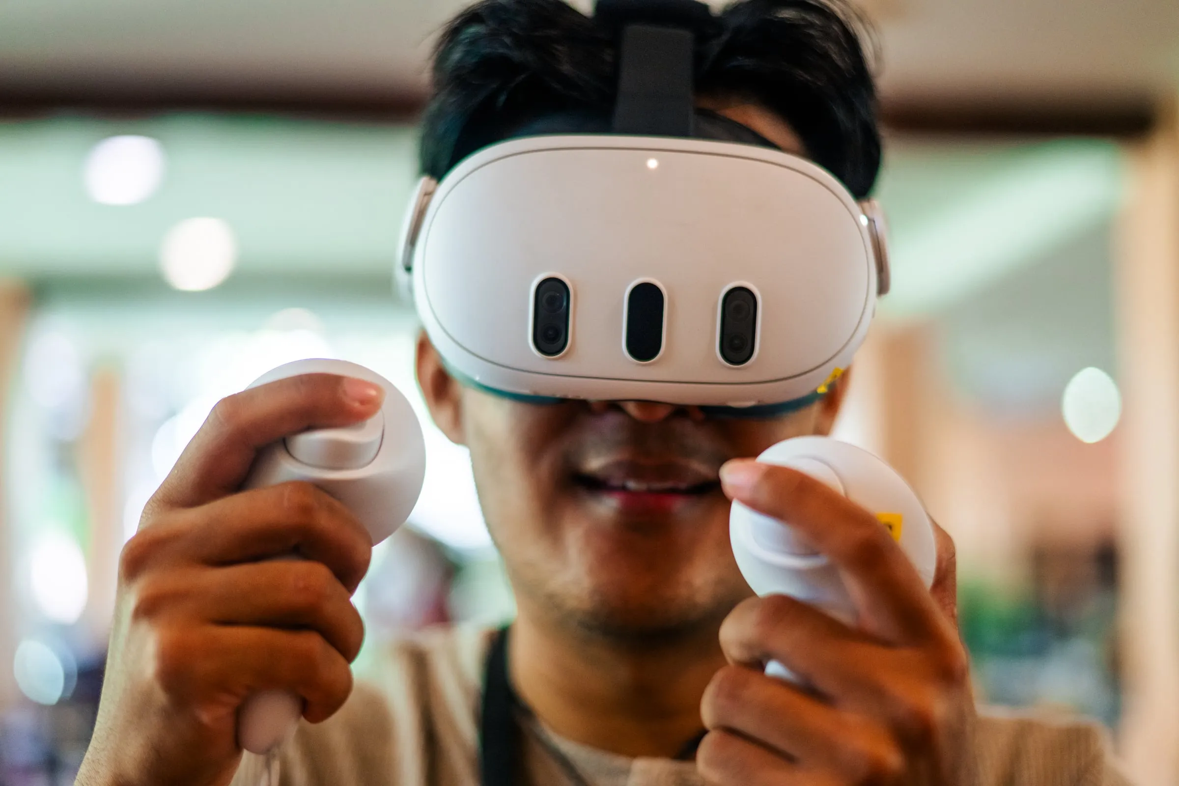 A workshop participant wearing a VR headset and holding two controllers, smiling